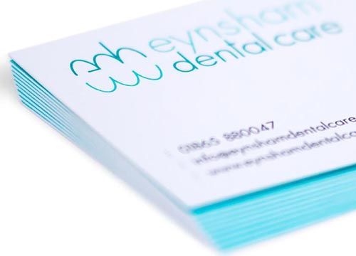 a close up of a stack of business cards for a dental care company .