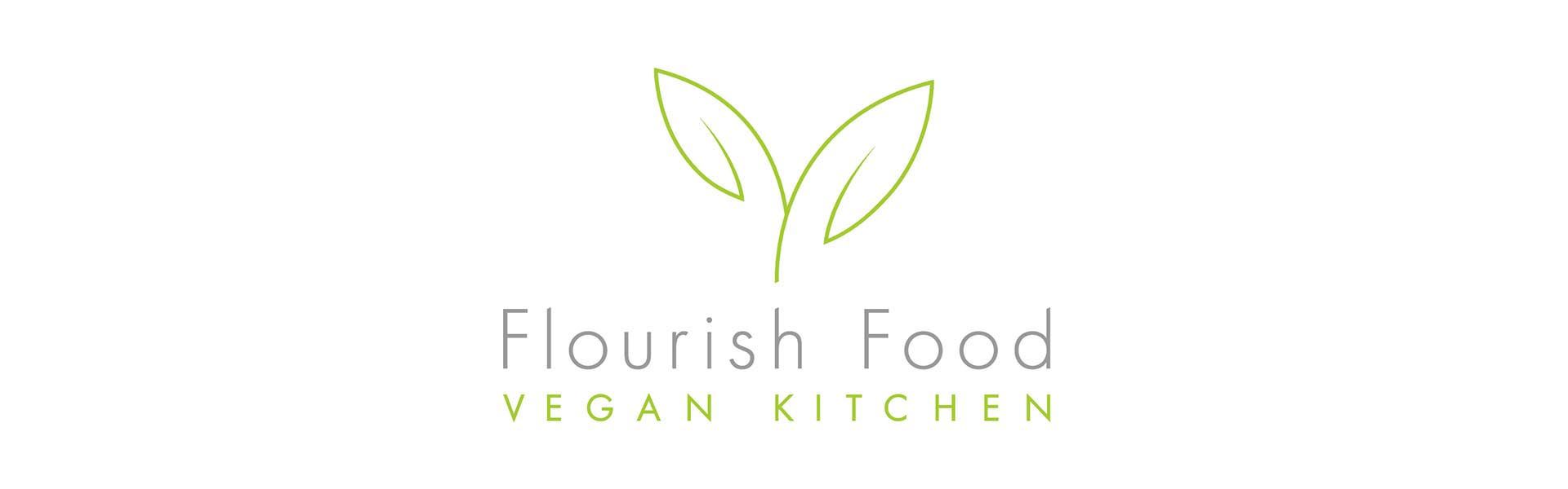 a logo for flourish food vegan kitchen with two green leaves