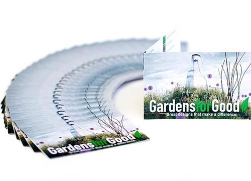 a stack of business cards for gardens for good are sitting on a table .