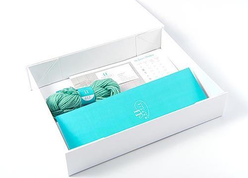 A white box filled with yarn and needlework supplies.