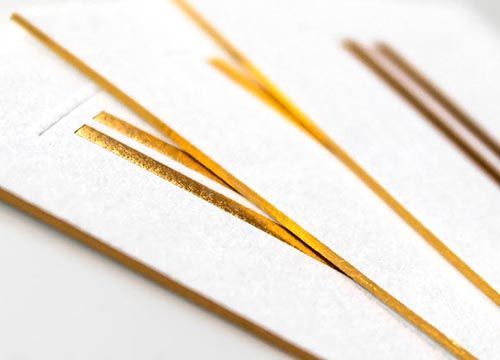 a close up of a set of gold foil edged business cards