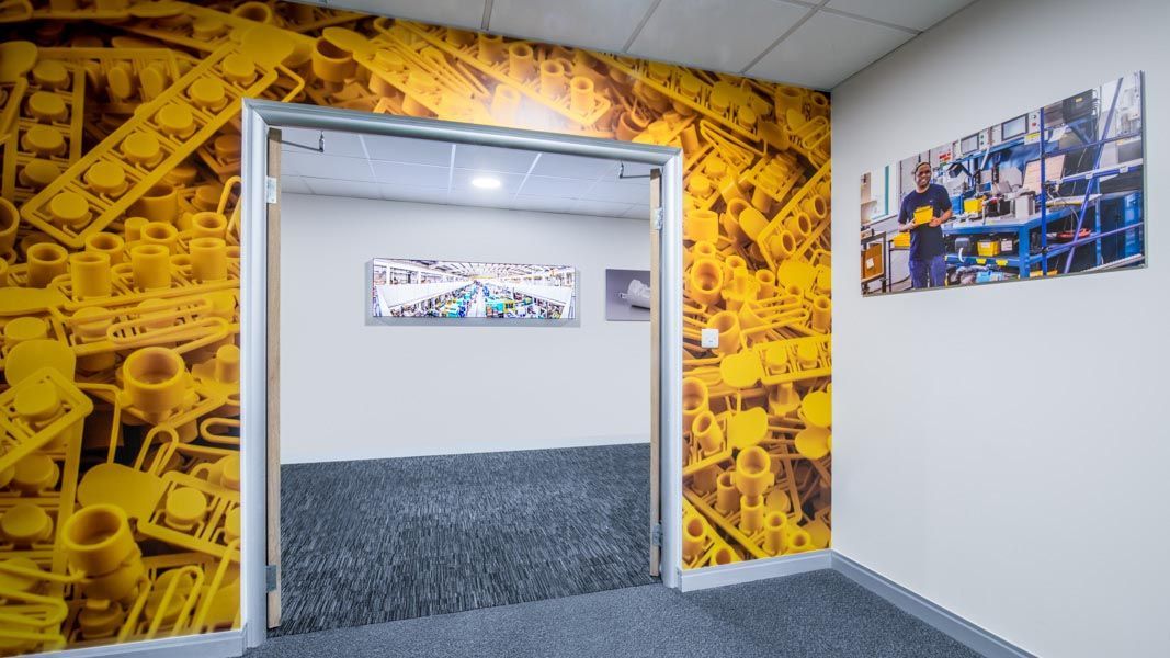 a hallway with a picture of a man in a factory on the wall
