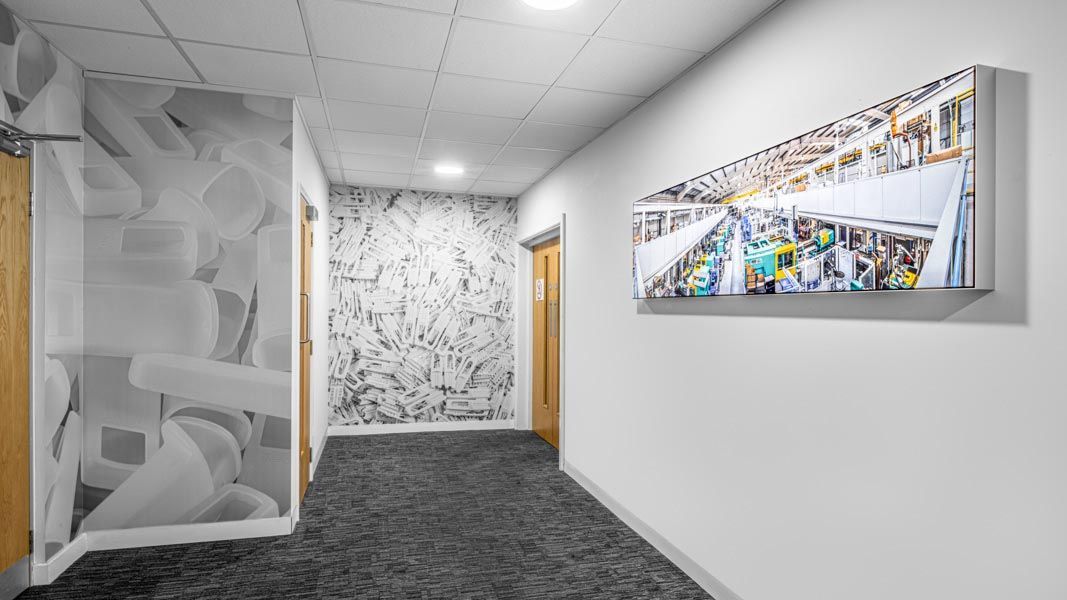 a hallway with a picture of a factory on the wall
