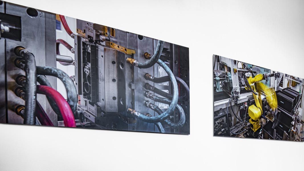 a picture of a machine with a yellow arm is hanging on a wall