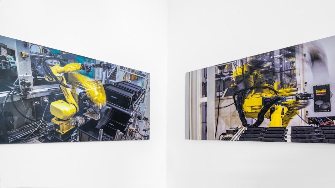 two pictures of a robotic arm on a wall