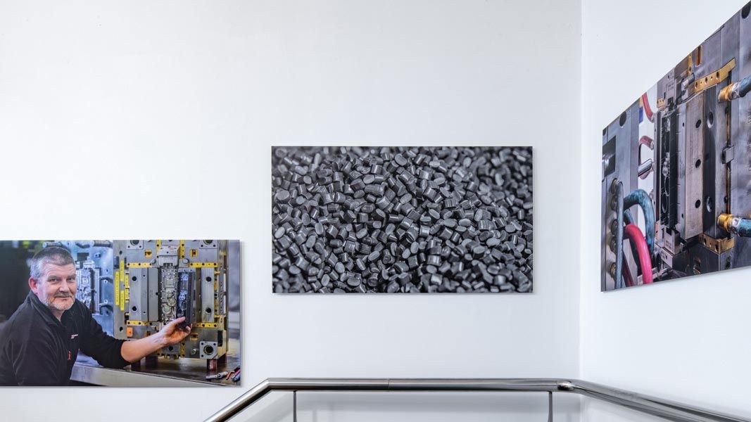 a picture of a man is hanging on a wall next to a picture of a pile of plastic injection moulding beads