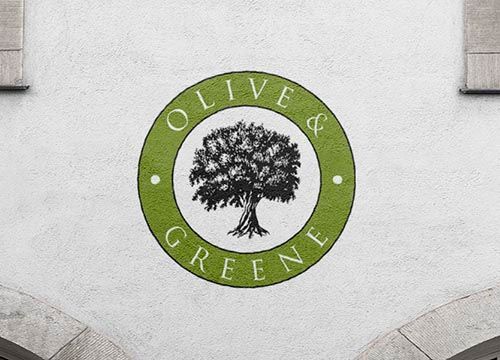 the logo for olive & greene is painted on the side of a building .