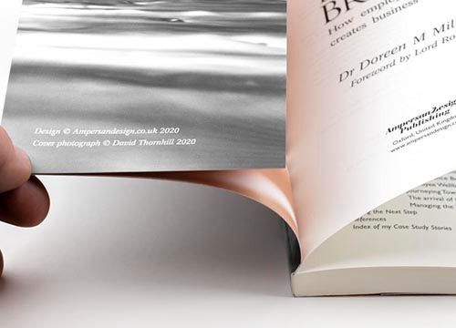 a person is holding a piece of paper in front of a book .