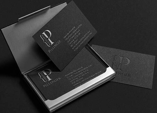a couple of business cards sitting on top of each other in a black case .