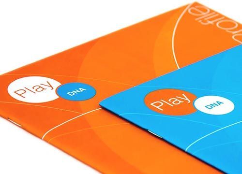 a close up of two play dna brochures on a white surface .