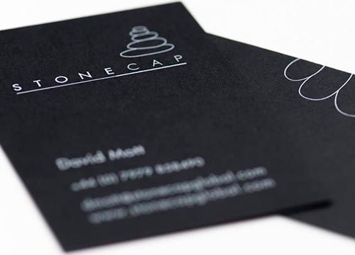a close up of two black business cards on a white surface .