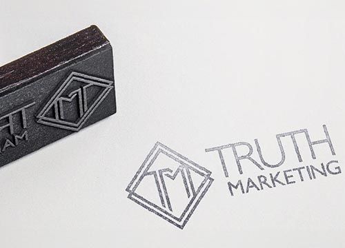 a stamp with the word truth marketing written on it is sitting on top of a piece of paper .