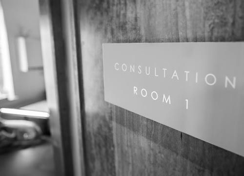 a black and white photo of a sign for consultation room 1 .
