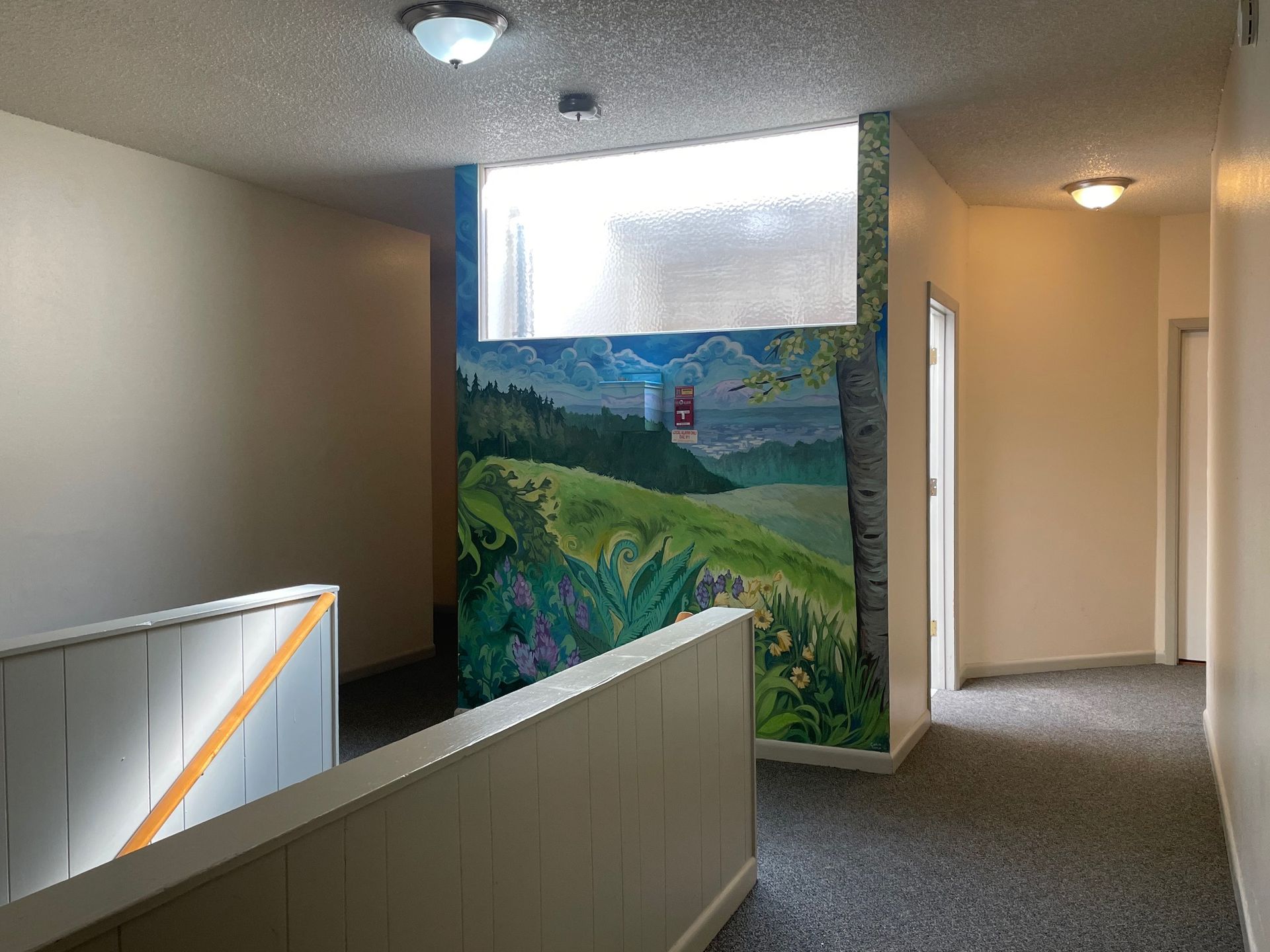 An empty hallway with a painting on the wall