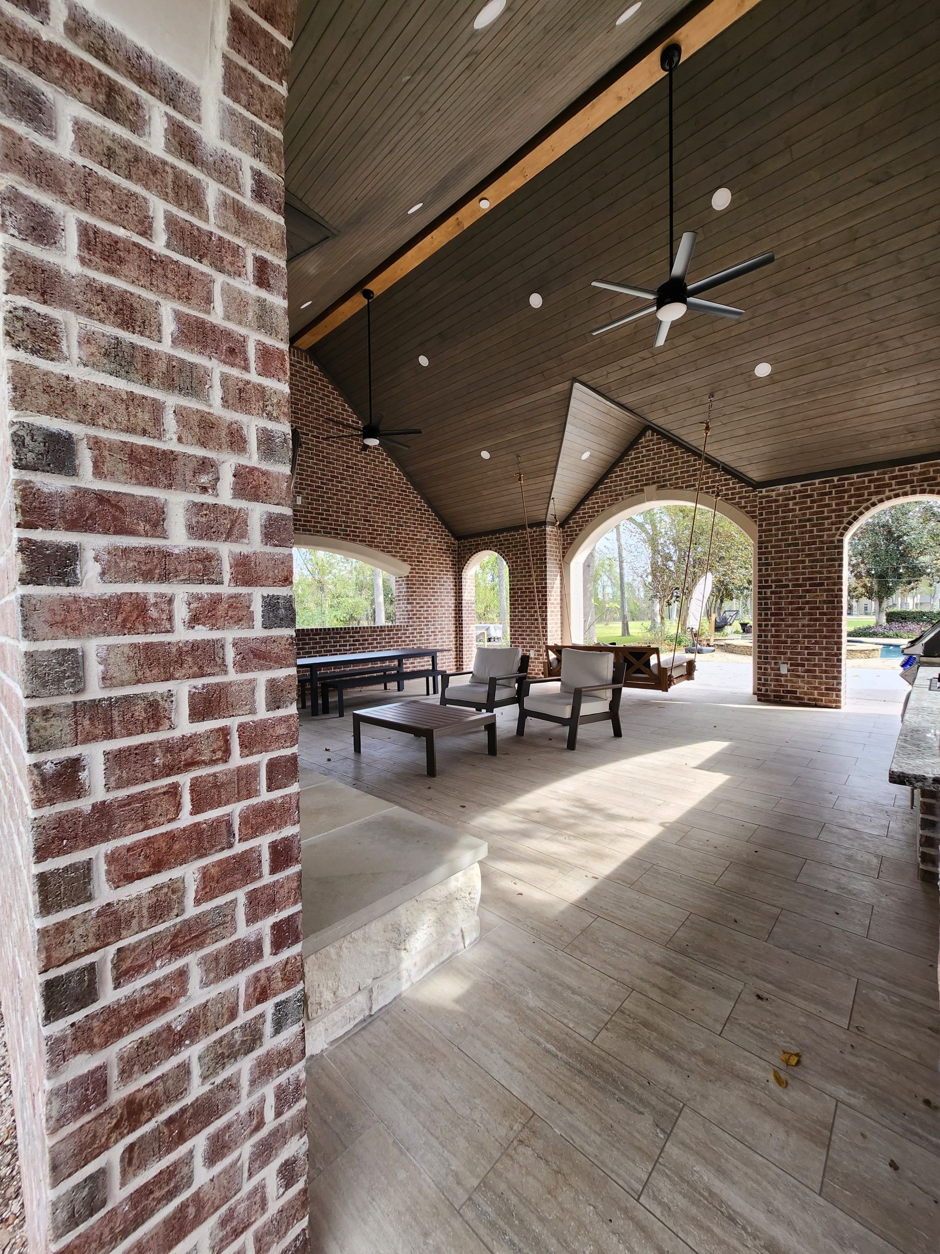 A living room with a brick wall and a ceiling fan.