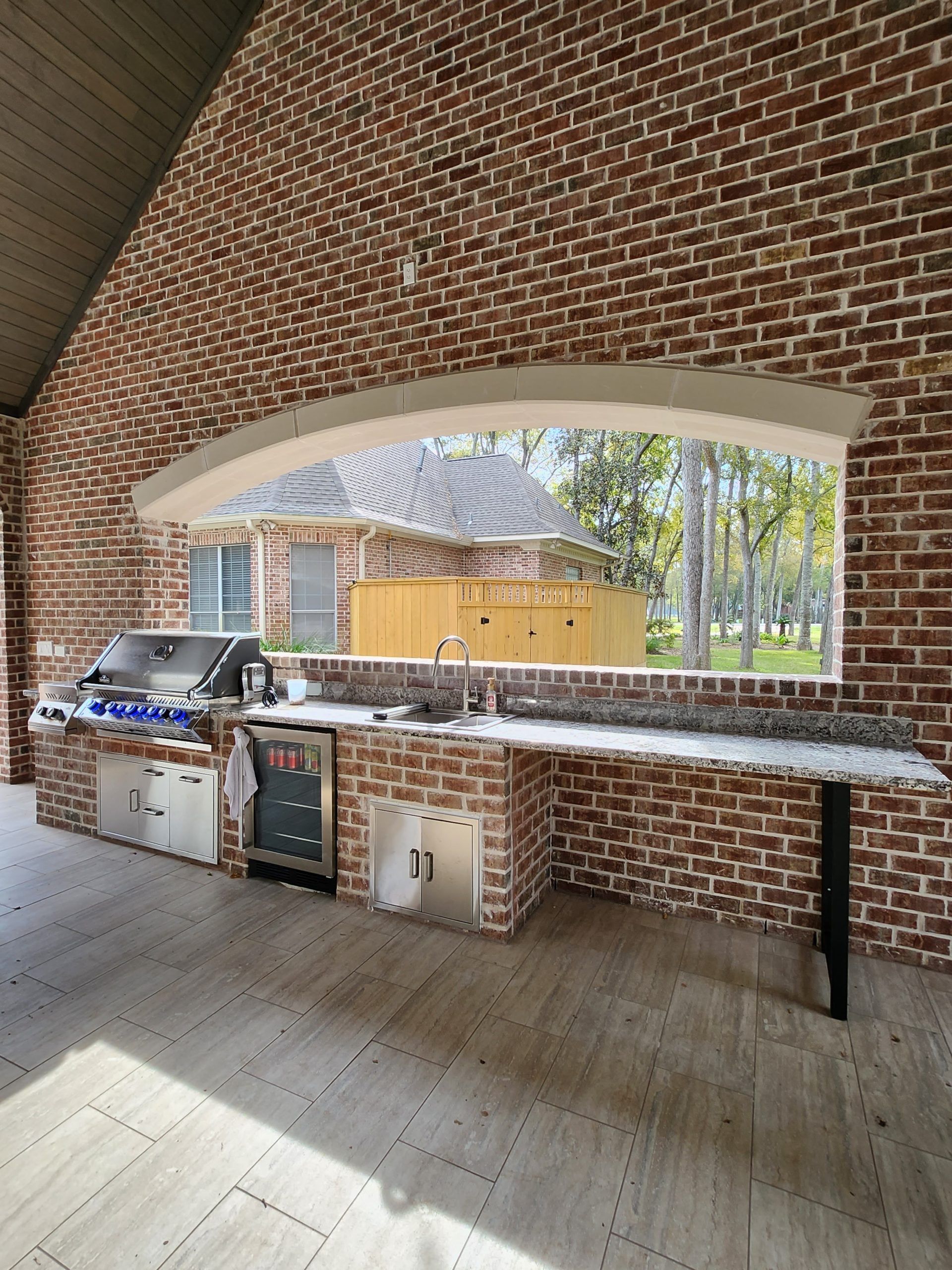 A kitchen with a brick wall and a large window