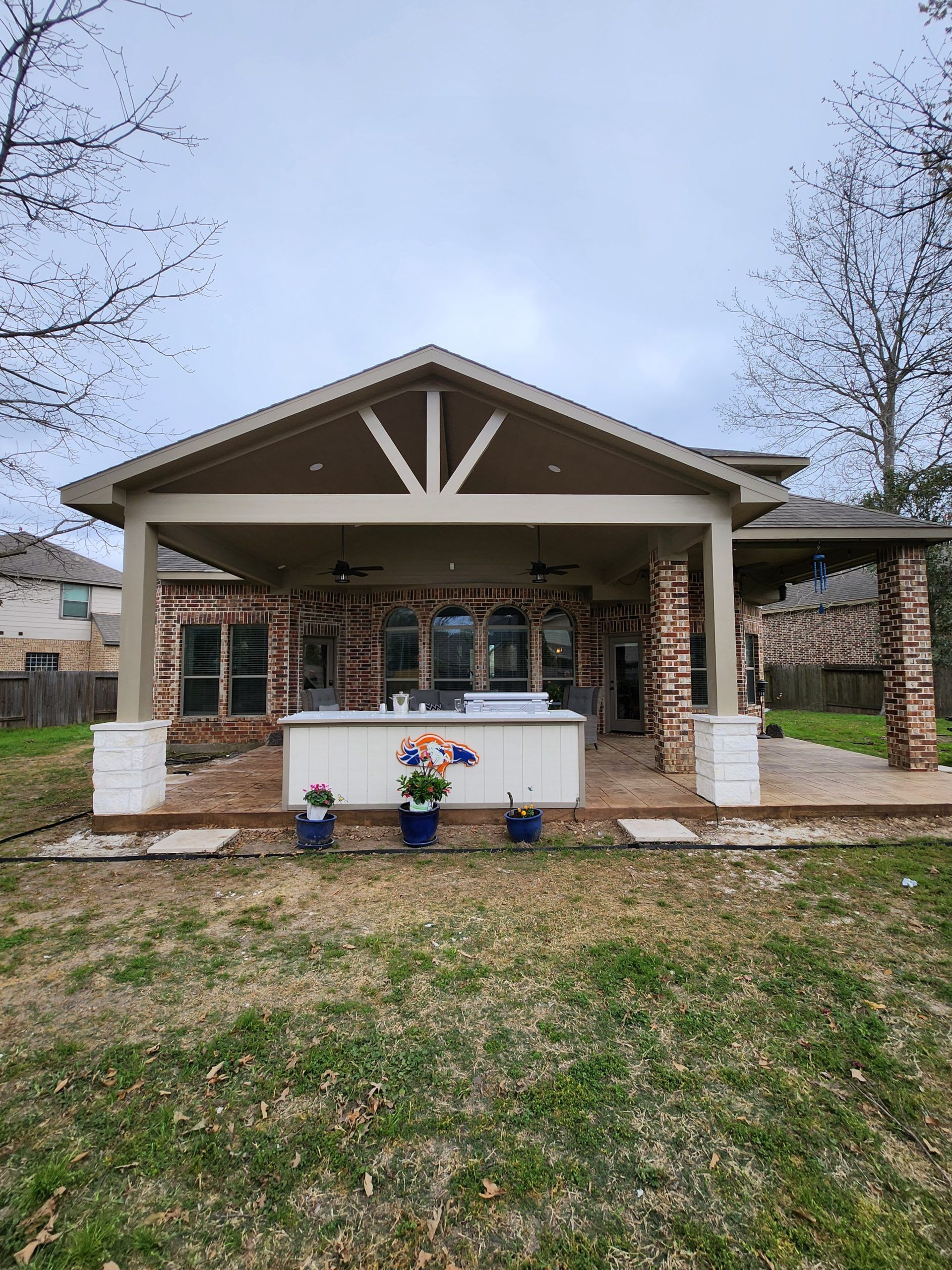 A house with a covered patio and a hot tub in the backyard.
