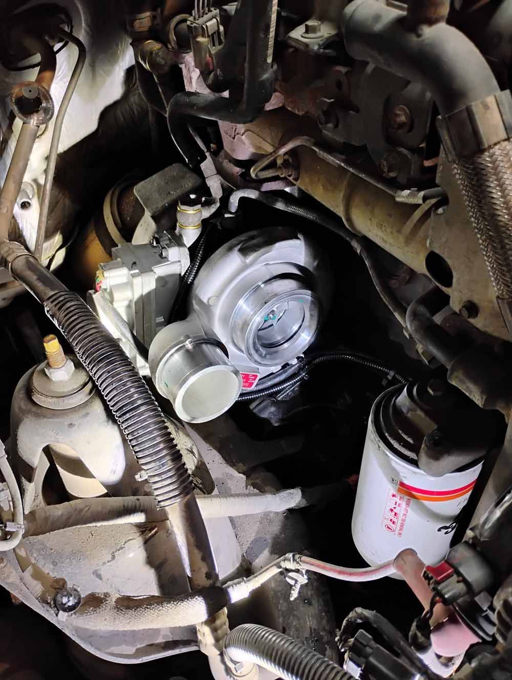 Engine compartment with a turbocharger in the center. Parts are gray, black, and silver.