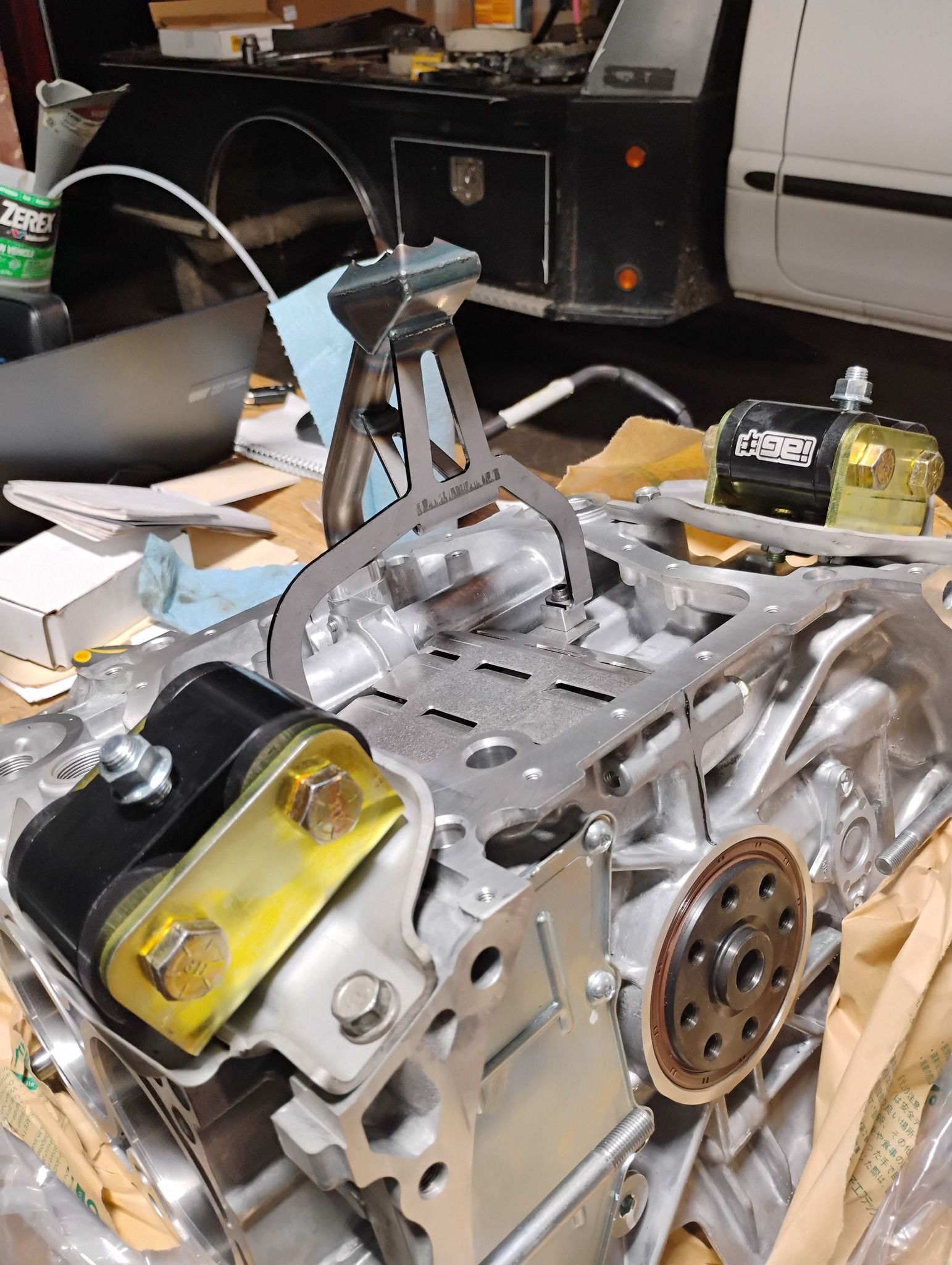 Engine block with tools, including a caliper, in a workshop setting.