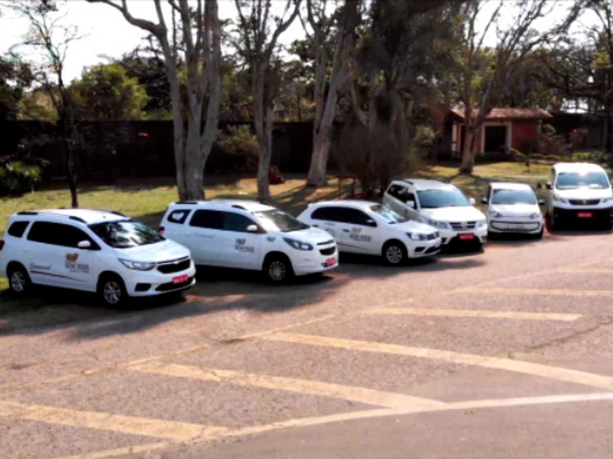 Uma fileira de carros brancos está estacionada em um estacionamento