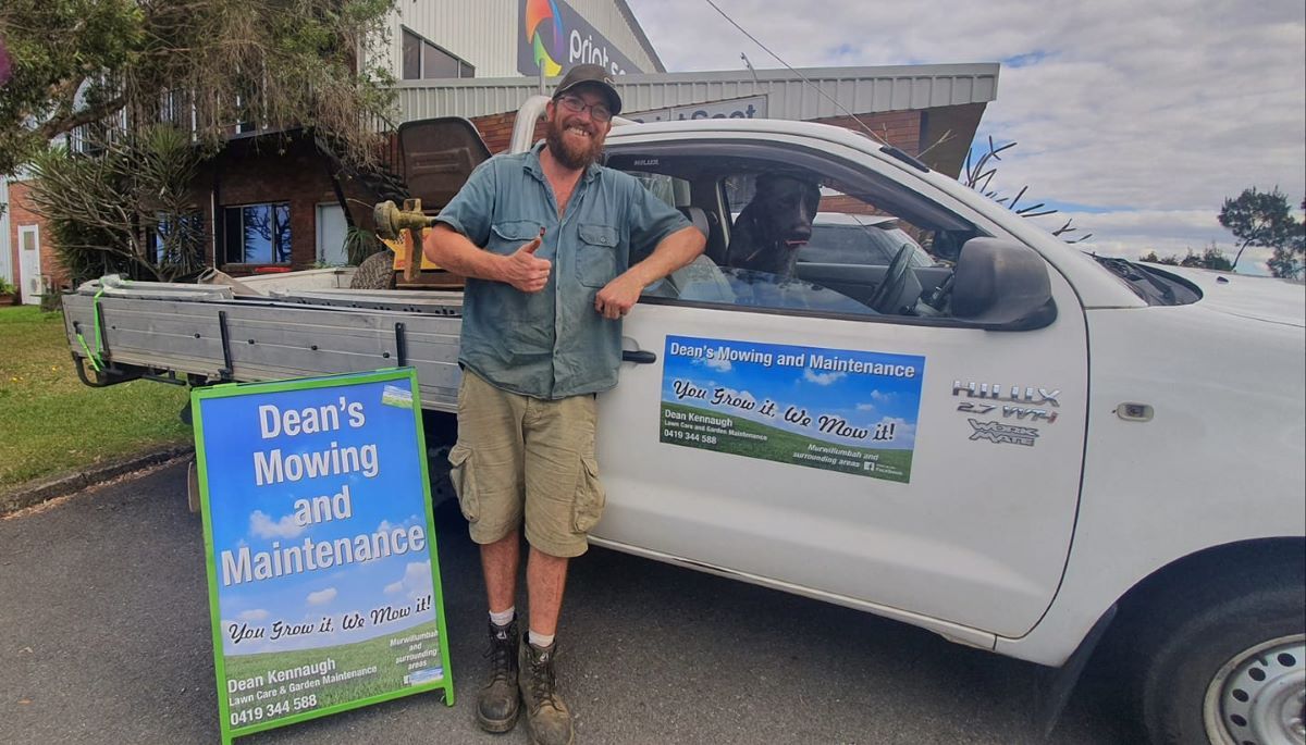 A Man is Standing Next to a Truck With a Sign in Front of It — Print Spot Group in Byron Bay, NSW