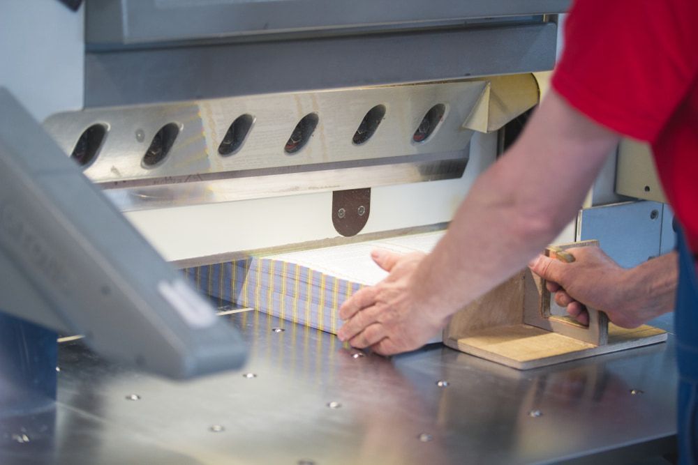 A Man is Cutting a Stack of Paper With a Machine — Print Spot Group in South Murwillumbah, NSW