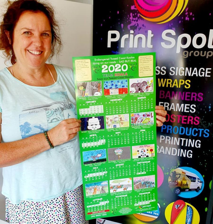 A Woman is Holding a Calendar — Print Spot Group in Kingscliff, NSW