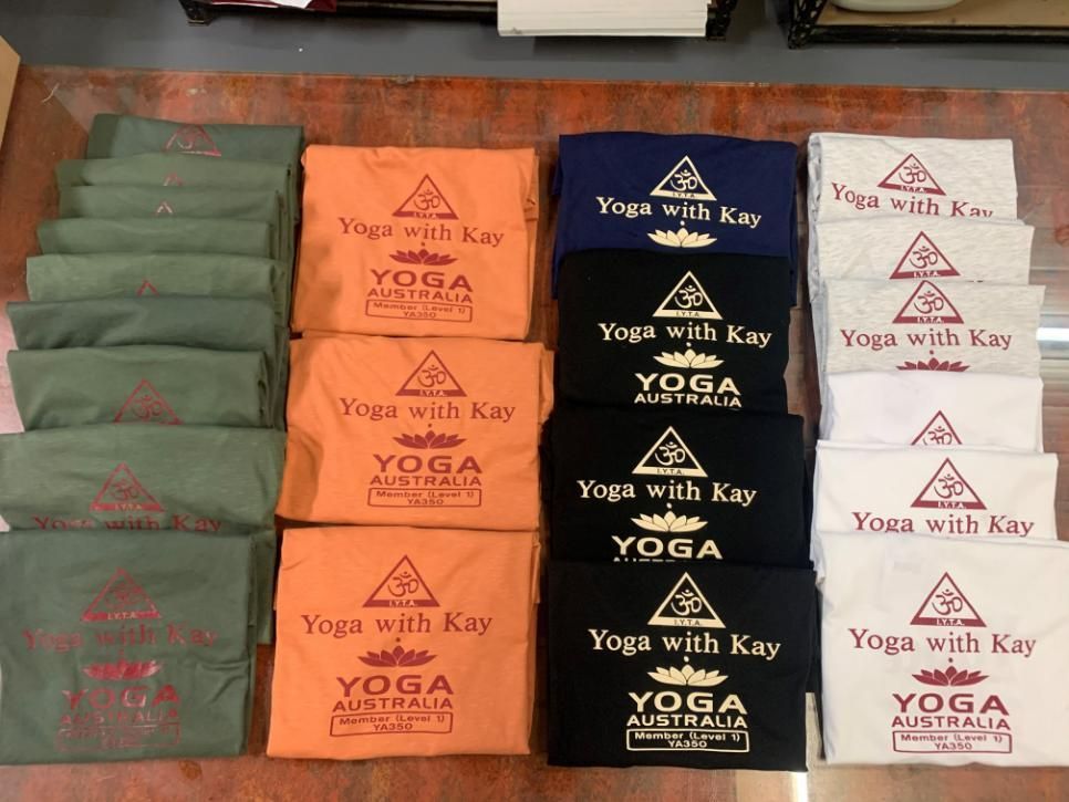 A Bunch Of Yoga With Kay T-Shirts Are Stacked On Top Of Each Other — Print Spot Group in South Murwillumbah, NSW