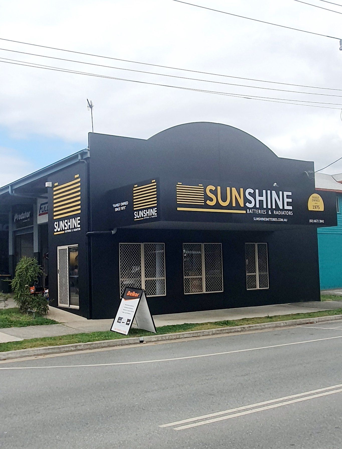 A Black Building With a Sign That Says Sunshine on It — Print Spot Group in South Murwillumbah, NSW