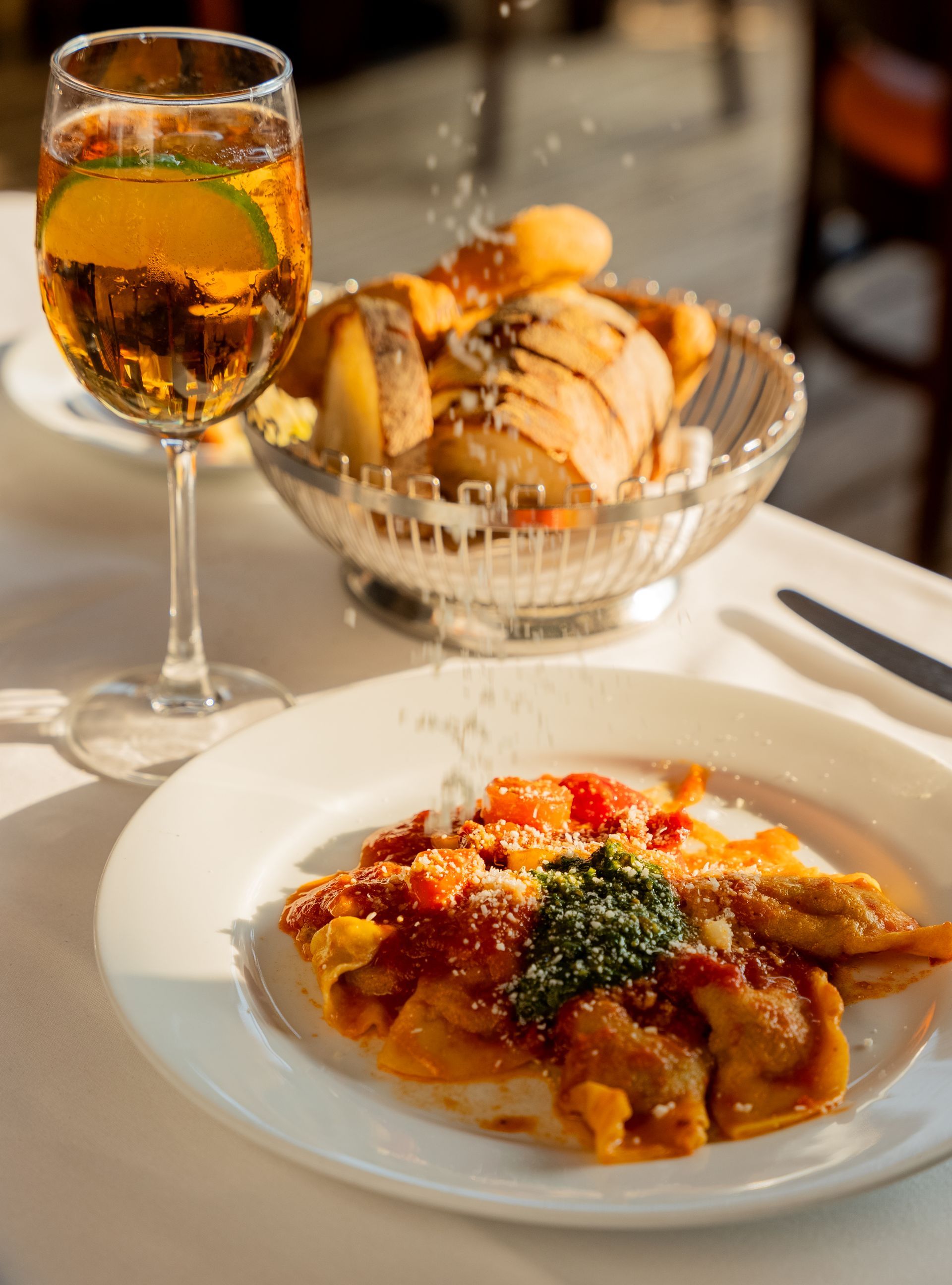 A plate of food and a glass of wine on a table.