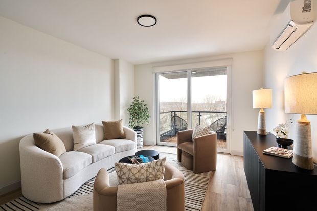 A living room with a couch and chairs and a balcony