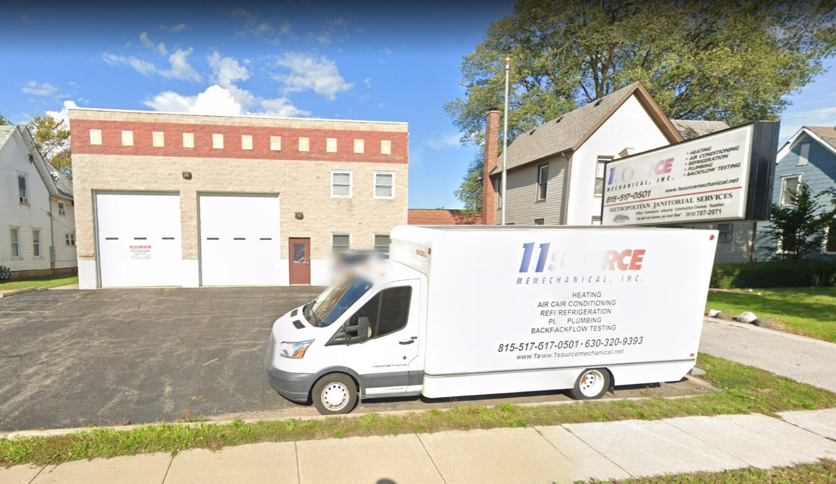 A white van is parked in front of a building.