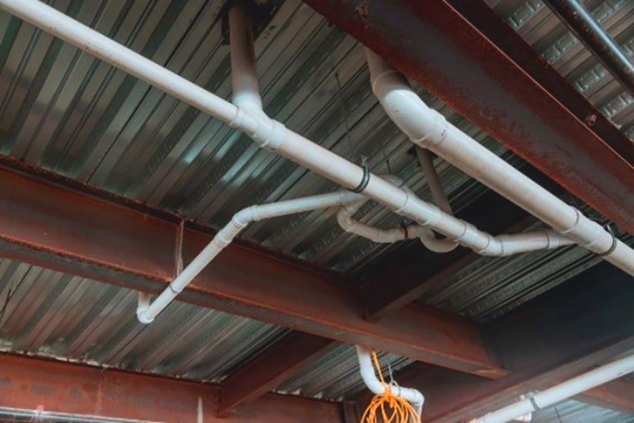 someone looking up at pipes in an effort to learn what is backflow testing
