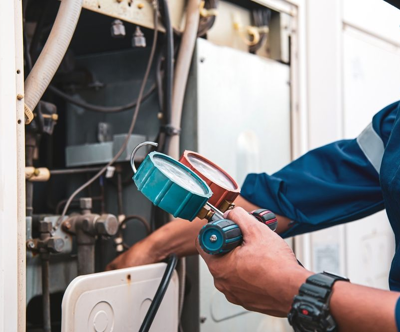Commercial HVAC technician maintaining an HVAC system