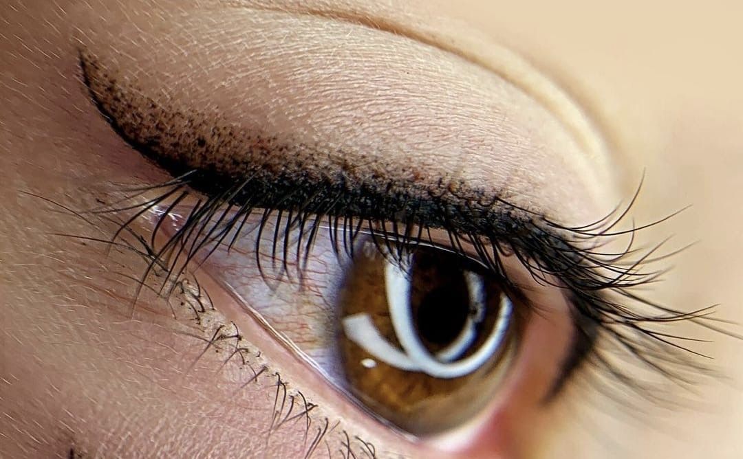 A close-up view of an eye featuring dark, winged eyeliner and long, defined eyelashes.