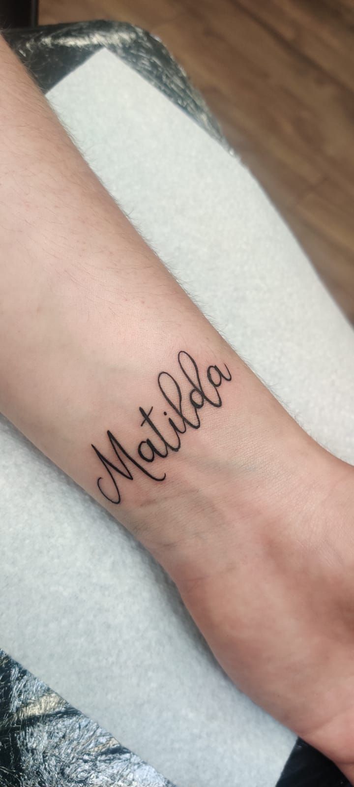 A forearm with a tattoo of the name