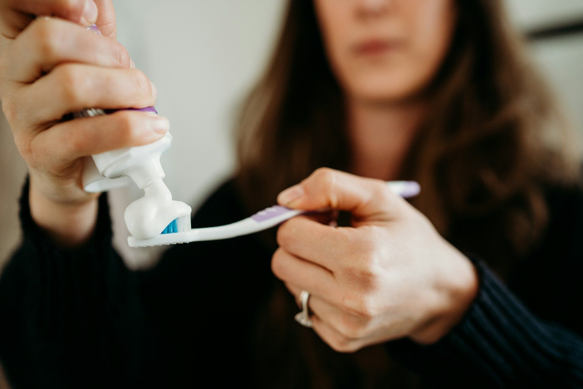 putting toothpaste on toothbrush