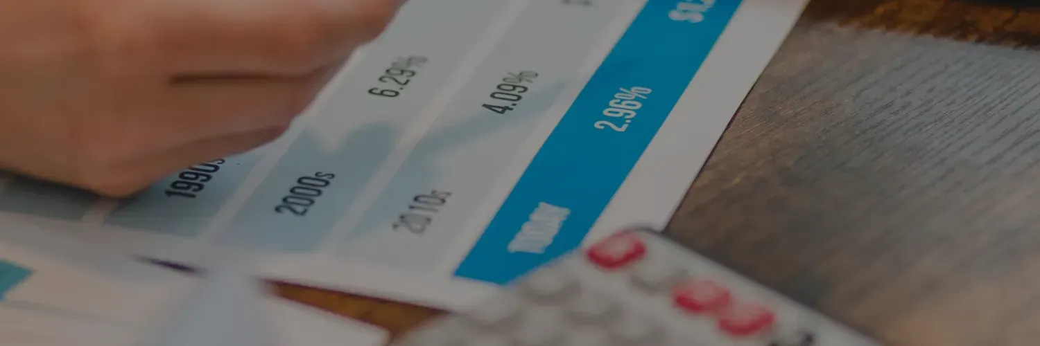 Hand holding a smartphone over a table with a blue and white app screen visible