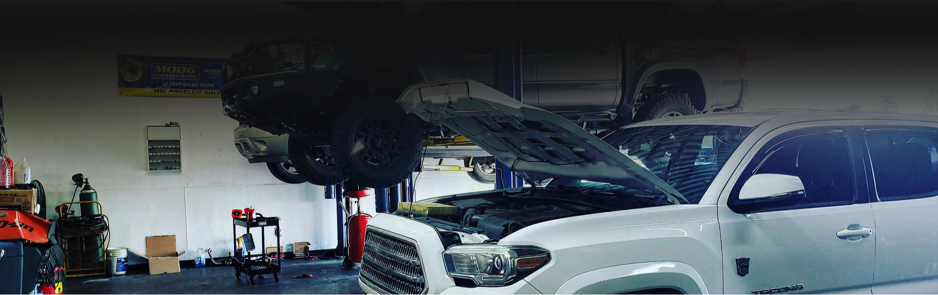 White SUV in a garage with its hood open, parked beside tools and equipment | 4G Automotive and Transmission