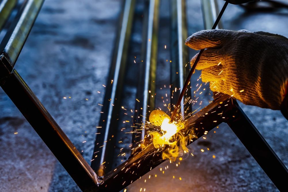 A person is welding a piece of metal with a welding torch.