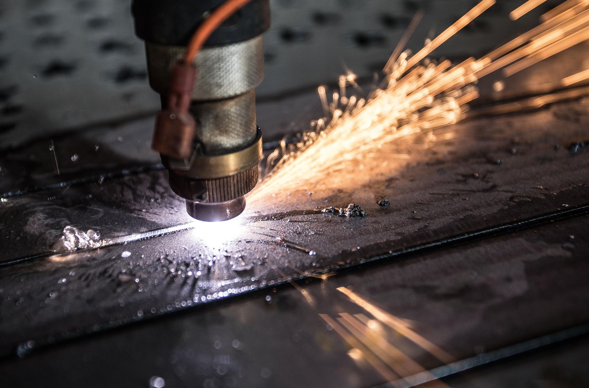A machine is cutting a piece of metal with sparks coming out of it.