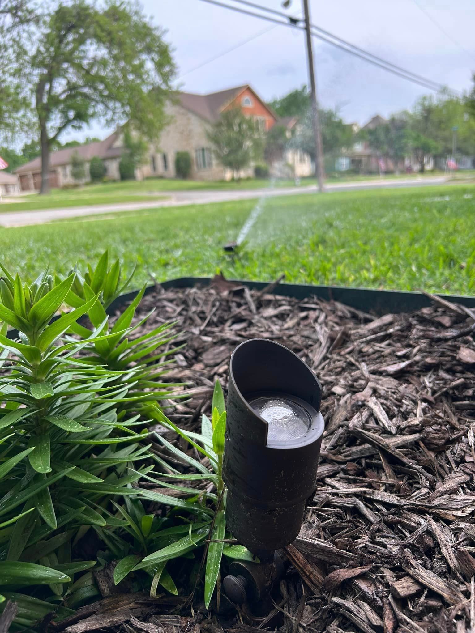 A Sprinkler Is Spraying Water on A Bush in A Garden - Collinsville, TX - L5 Irrigation