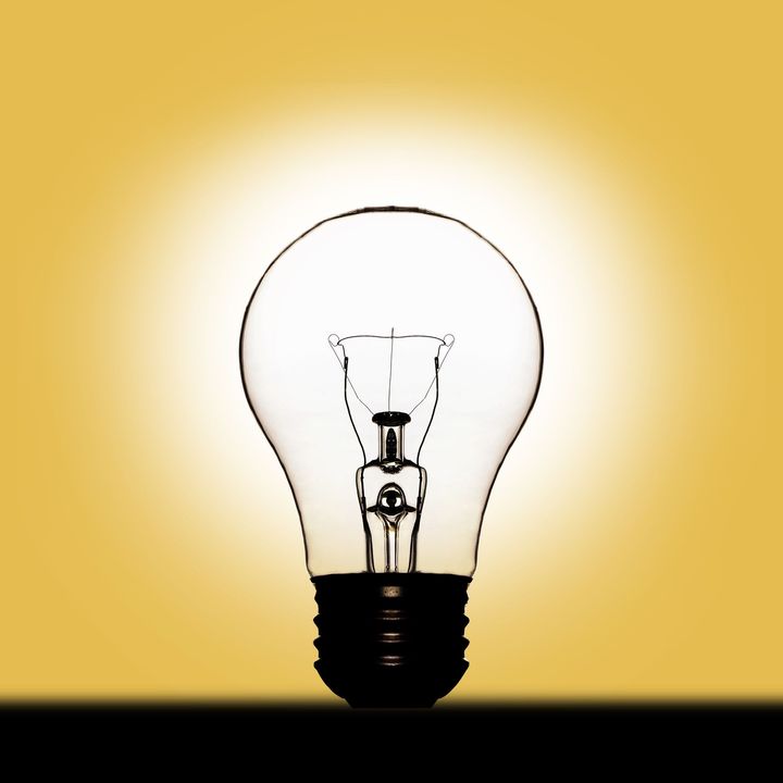 A light bulb is lit up on a yellow background