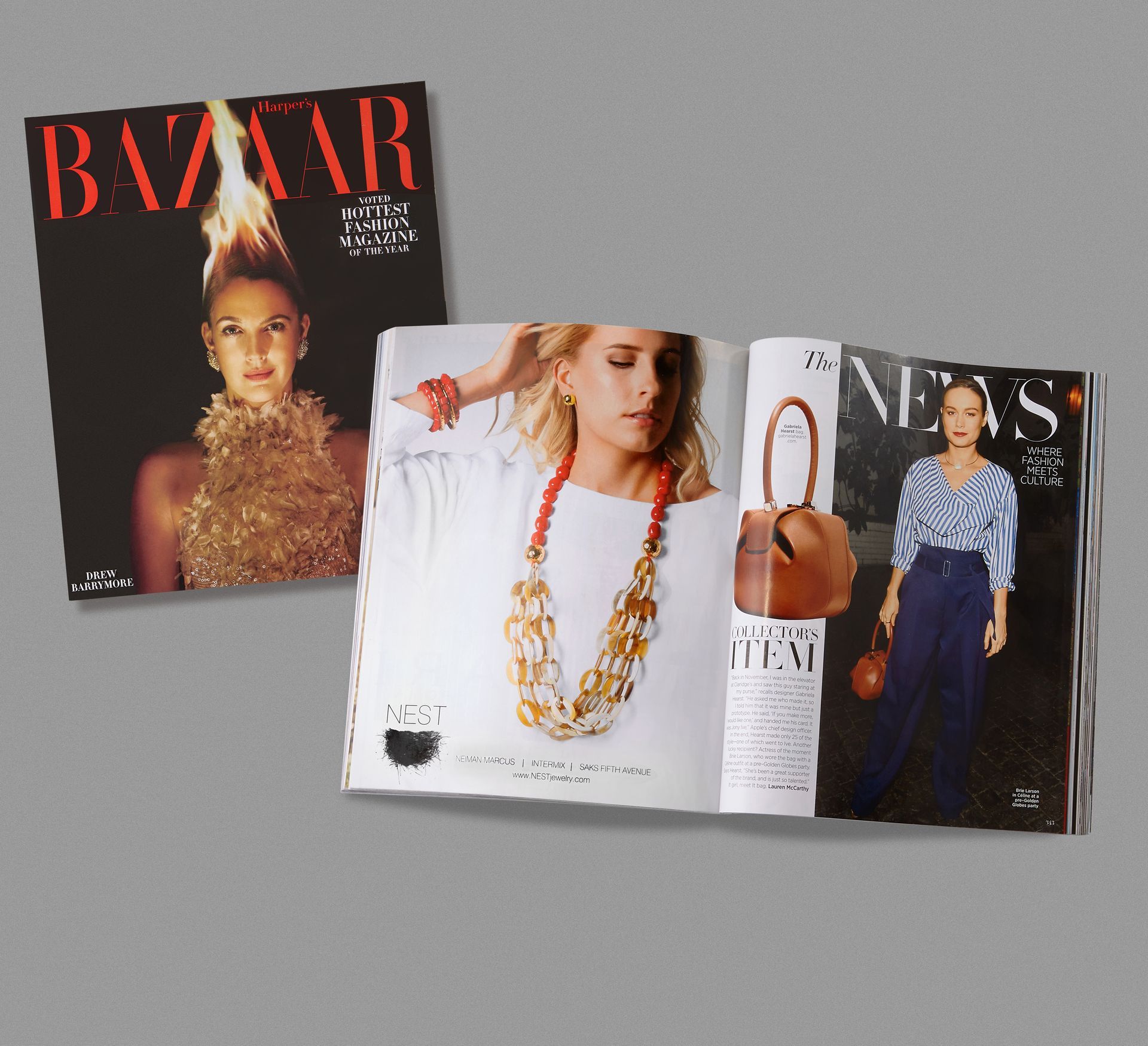 Magazines, one open, featuring a woman modeling jewelry and fashion; on gray surface.