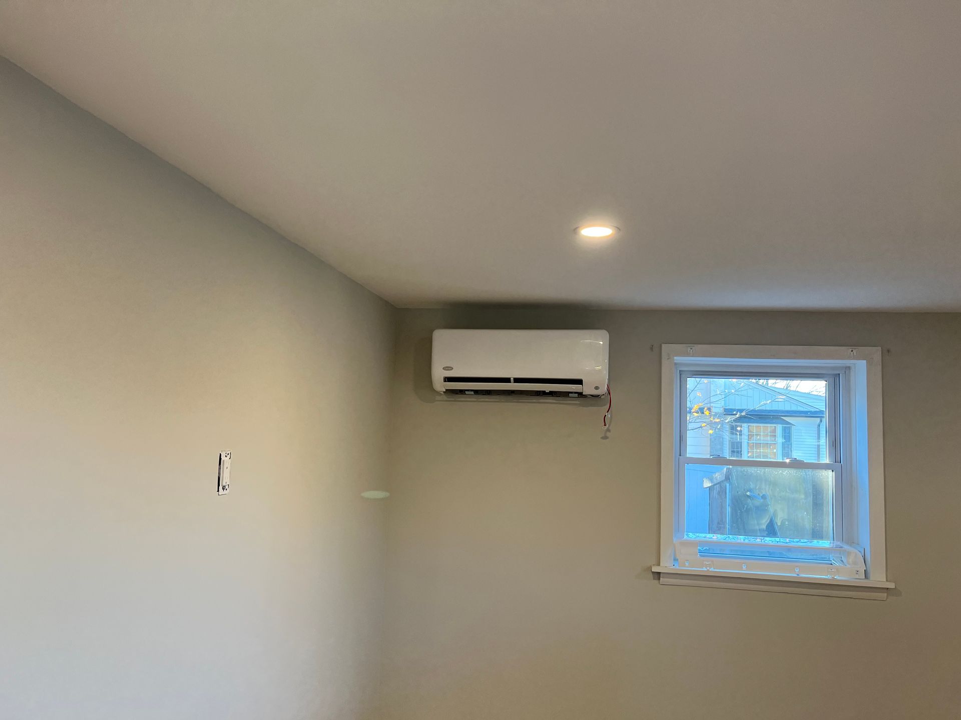 Woman using smartphone to control air conditioner in living room. Woman using smartphone to control air conditioner in living room.