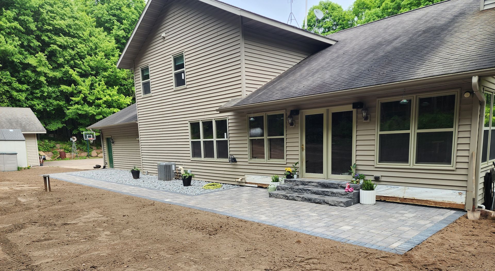A brick house with a stone retaining wall in front of it in Rothschild, Wisconsin