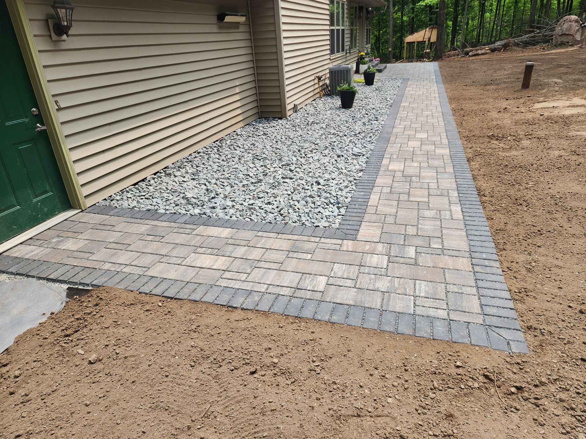 A brick walkway is being built in front of a house in Rothschild, Wisconsin