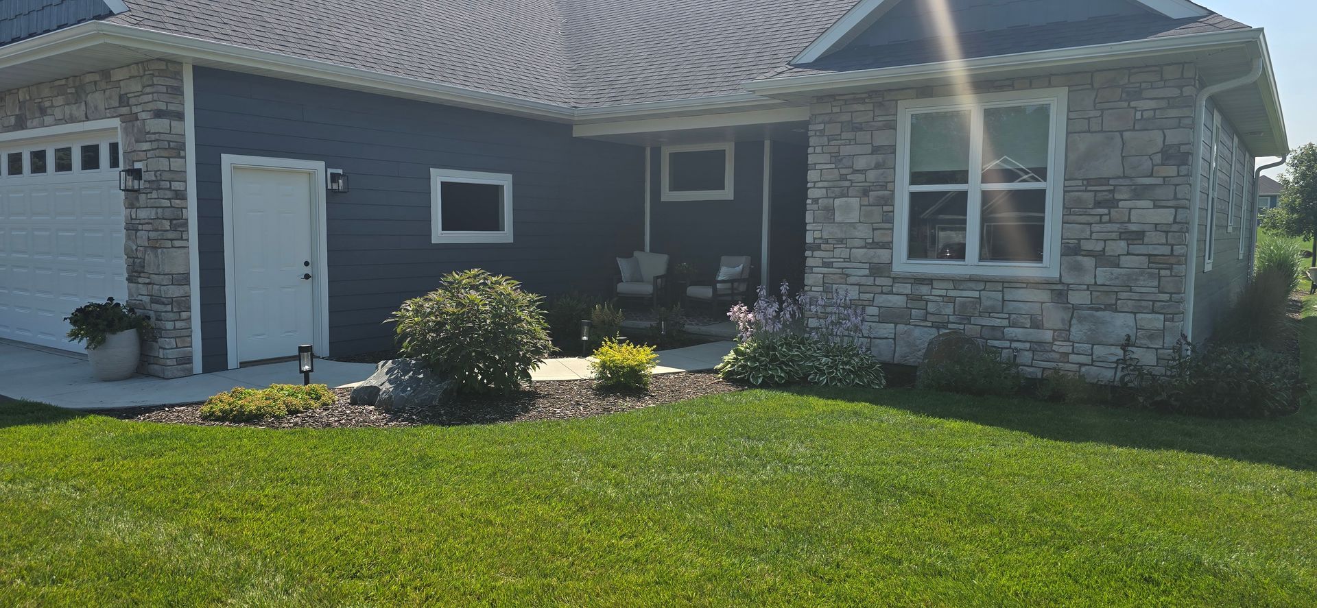 A house with a large lawn in front of it and a garage.