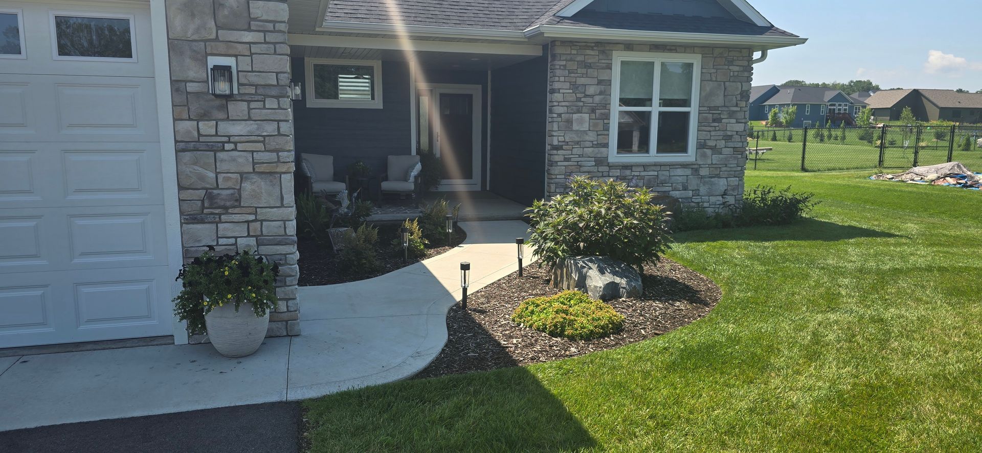 A house with a white garage door and a walkway leading to it.