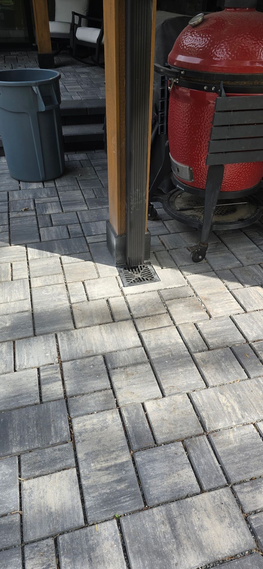 A patio with a drain with drain cover on it.
